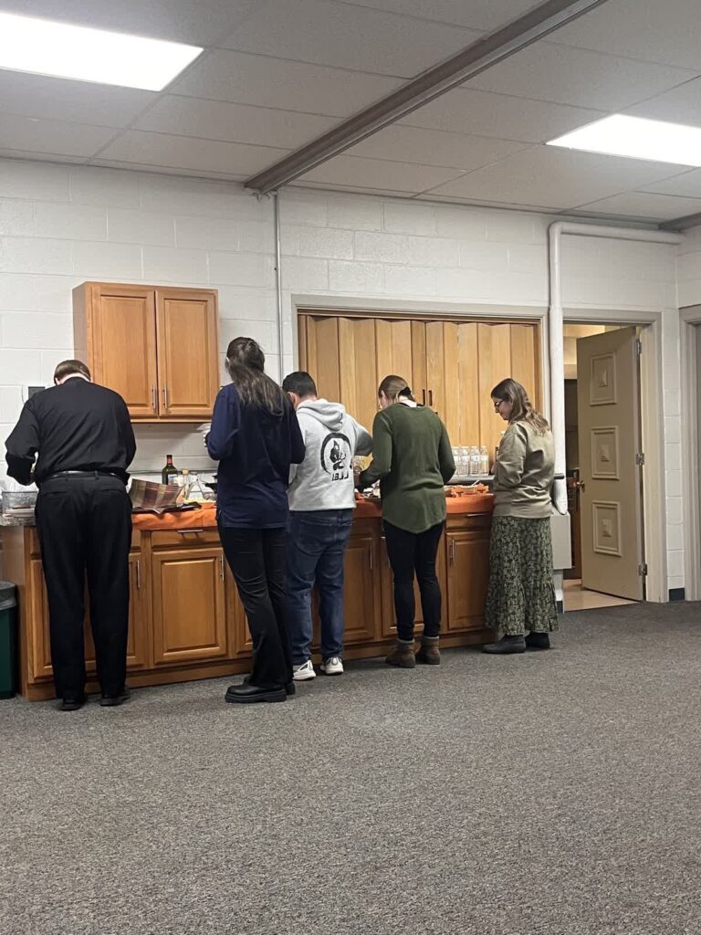 Group of young adults getting food in the parish hall